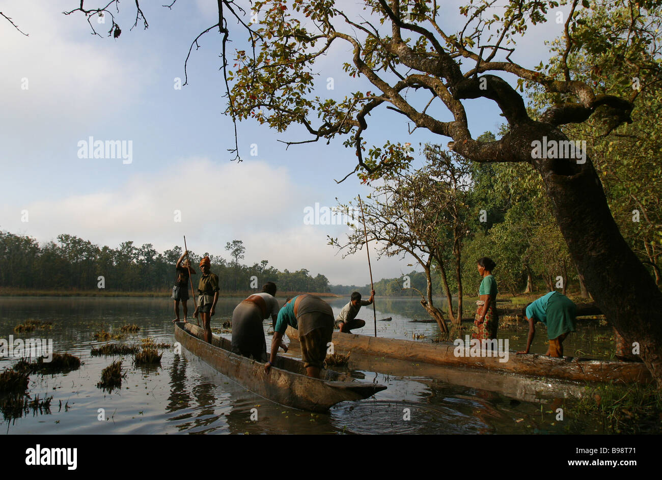 Lavoratori nepalesi board scavato canoe su un lago in Chitwan il parco nazionale nelle pianure subtropicali del Terai regione del Nepal. Foto Stock