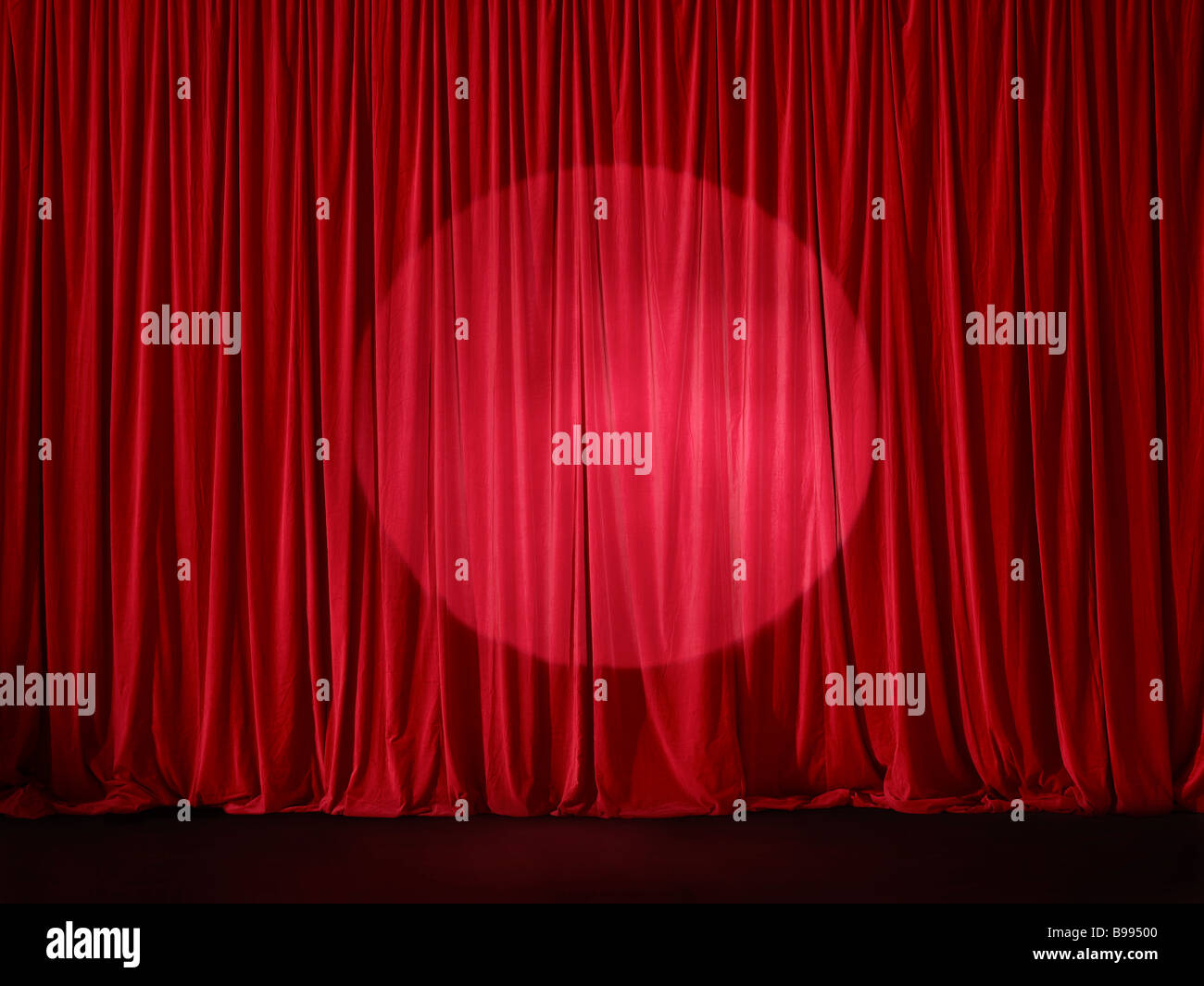 Red sipario di un palcoscenico spotlit Foto Stock