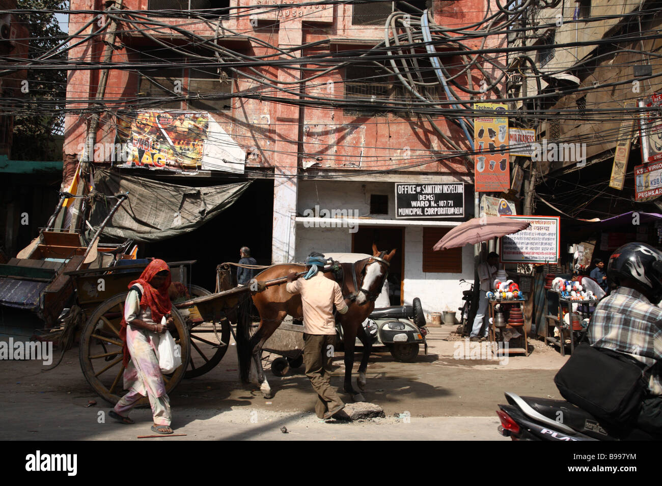 Un uomo imposta un carrello a cavallo della strada di Vecchia Delhi, India. Foto Stock