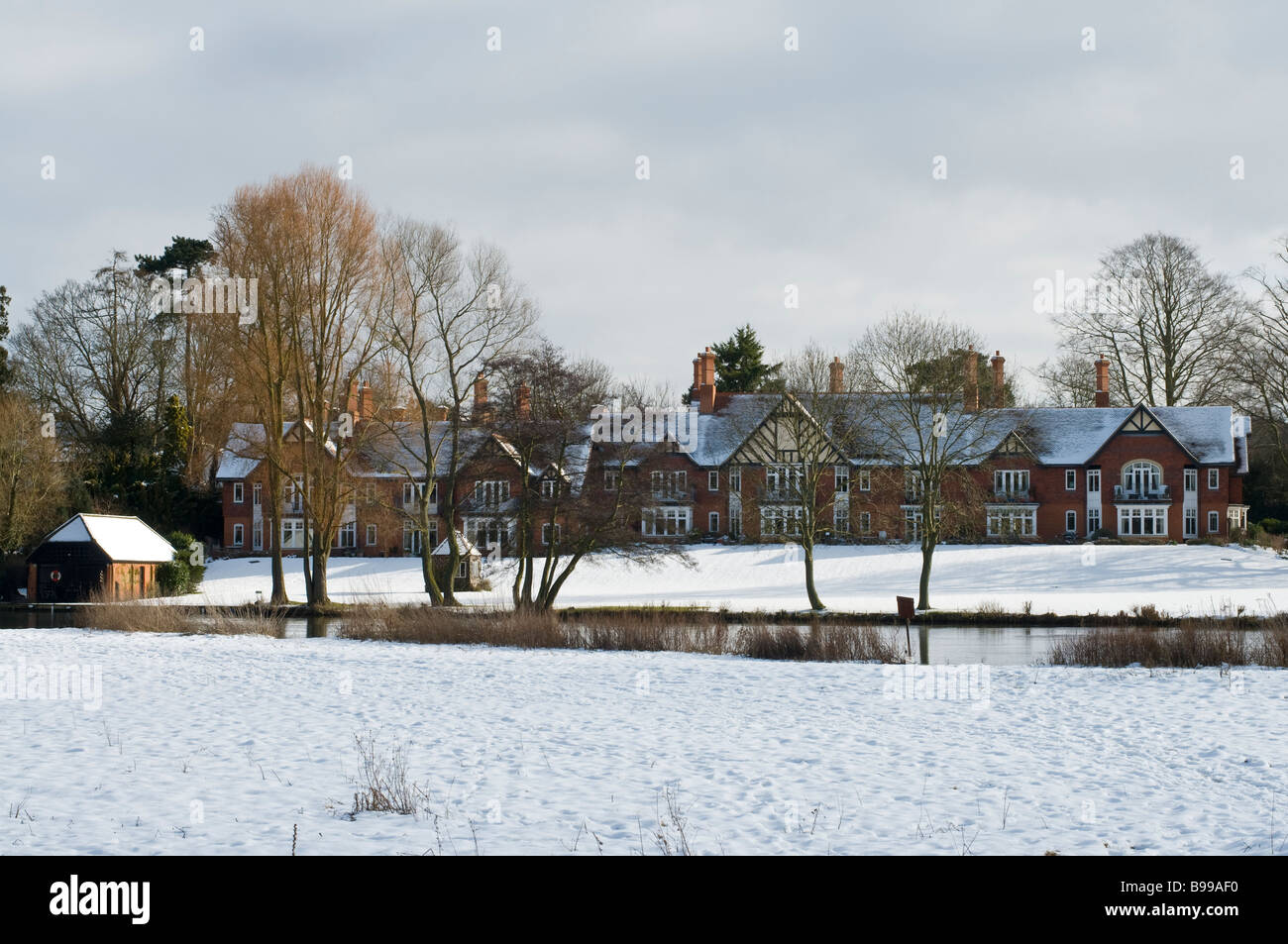 Una fila di case sotto la neve lungo il fiume Tamigi in Oxfordshire Foto Stock