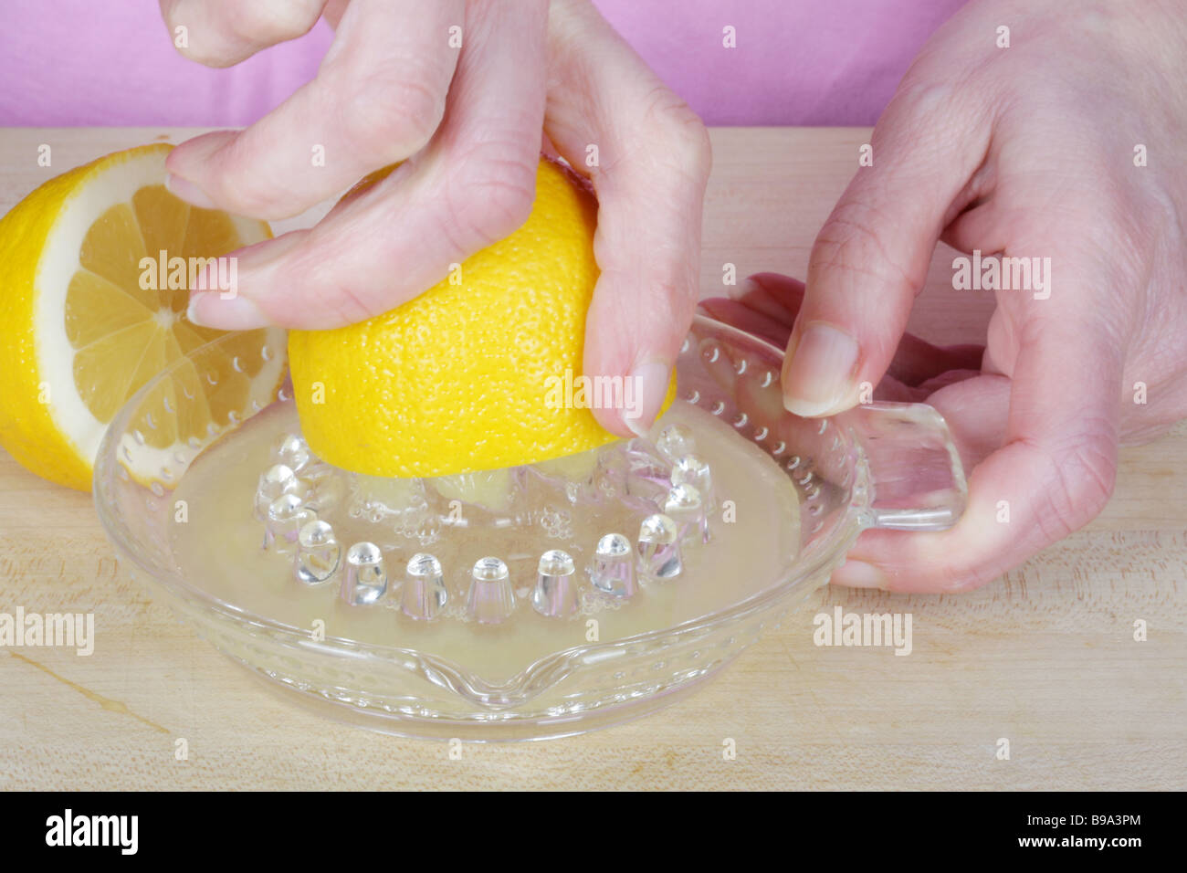 La donna a spremere il succo del limone Modello rilasciato Foto Stock