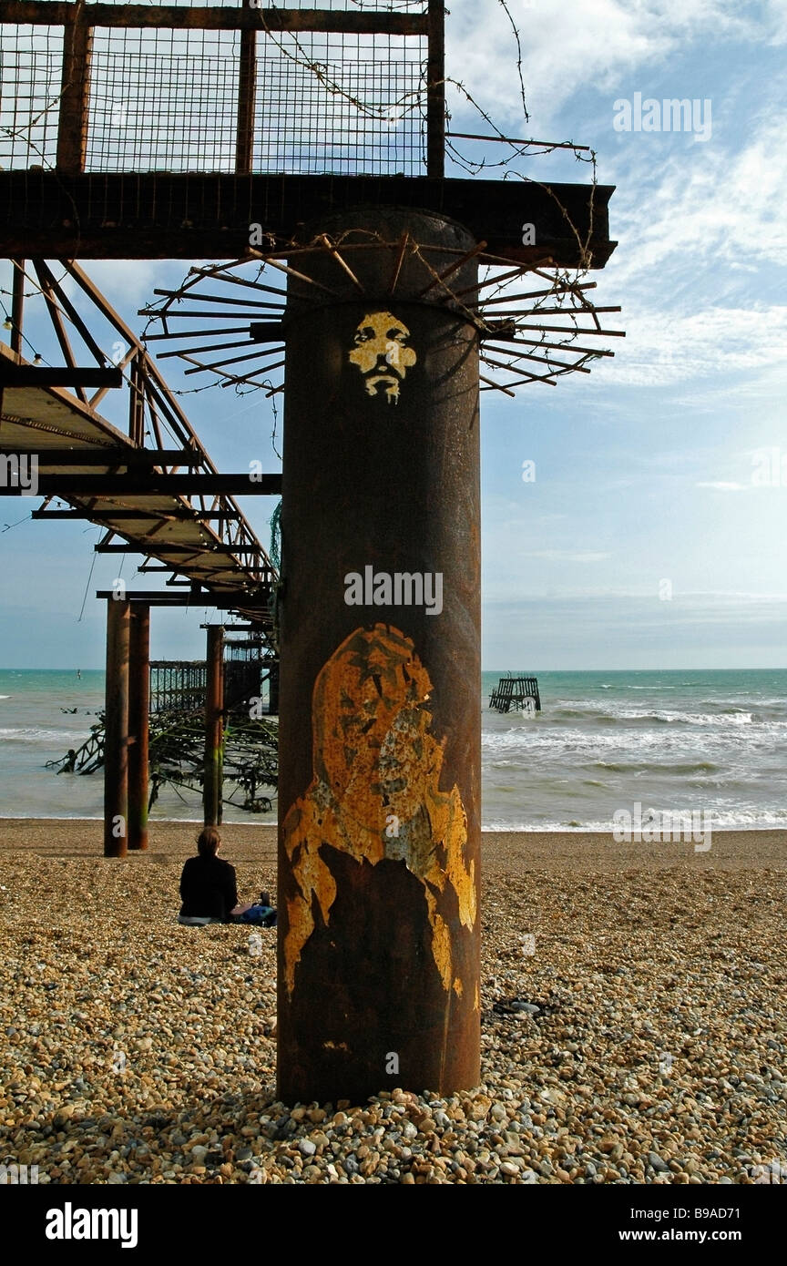 Un volto che rappresenta Gesù Cristo verniciato a spruzzo sul rusty resti del molo Ovest di Brighton, Sussex, Regno Unito. Foto Stock