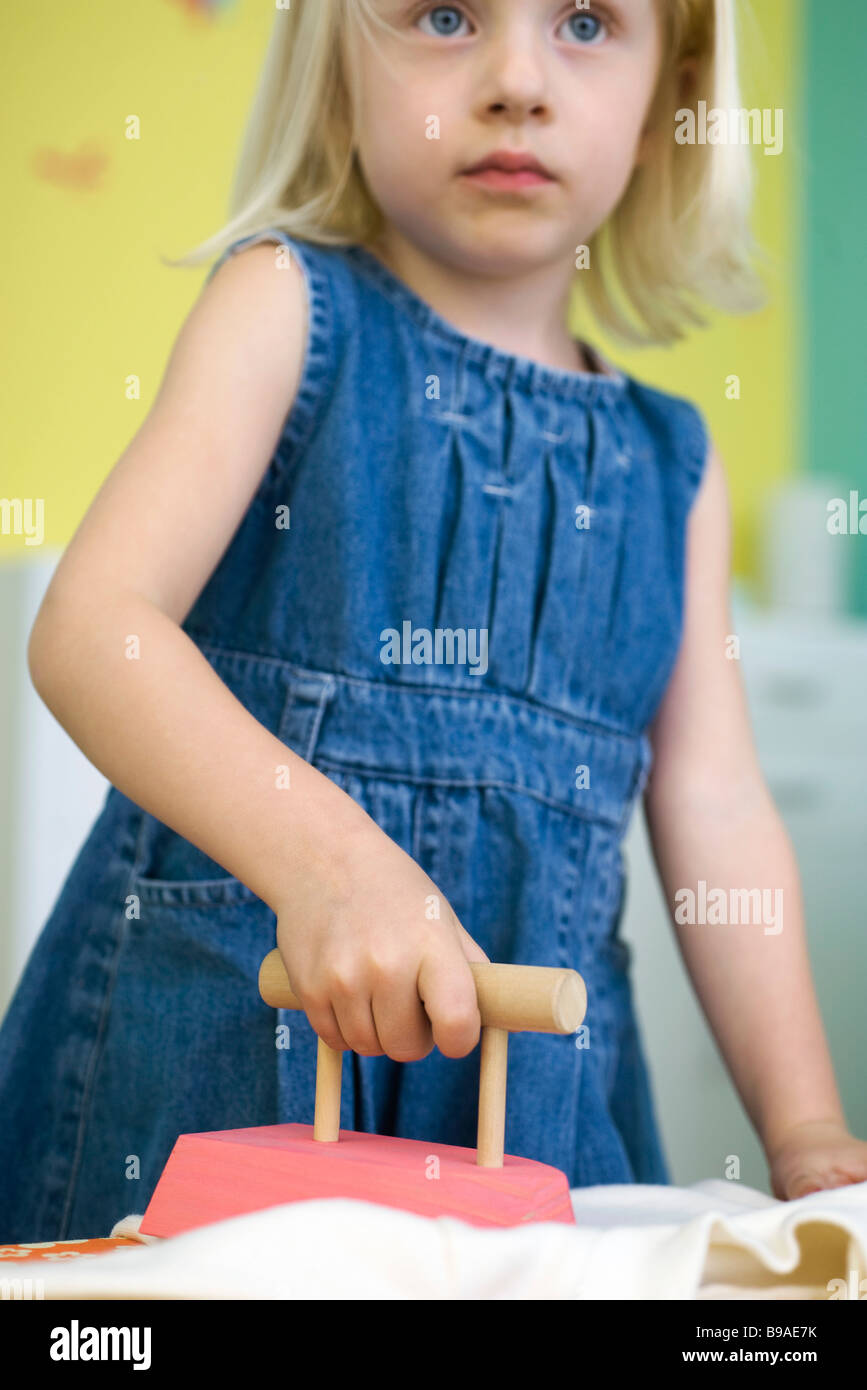 Bambina a stirare con il ferro da stiro giocattolo Foto stock - Alamy