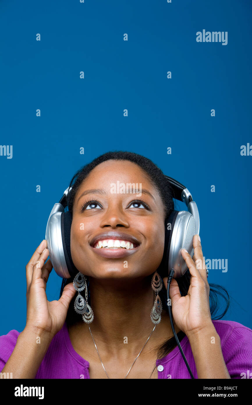 Donna l'ascolto di musica con le cuffie Foto Stock