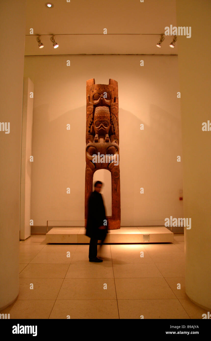 Un visitatore al British Museum di Londra passando davanti ad un lifesize scultura in legno. ISO 400 Foto Stock