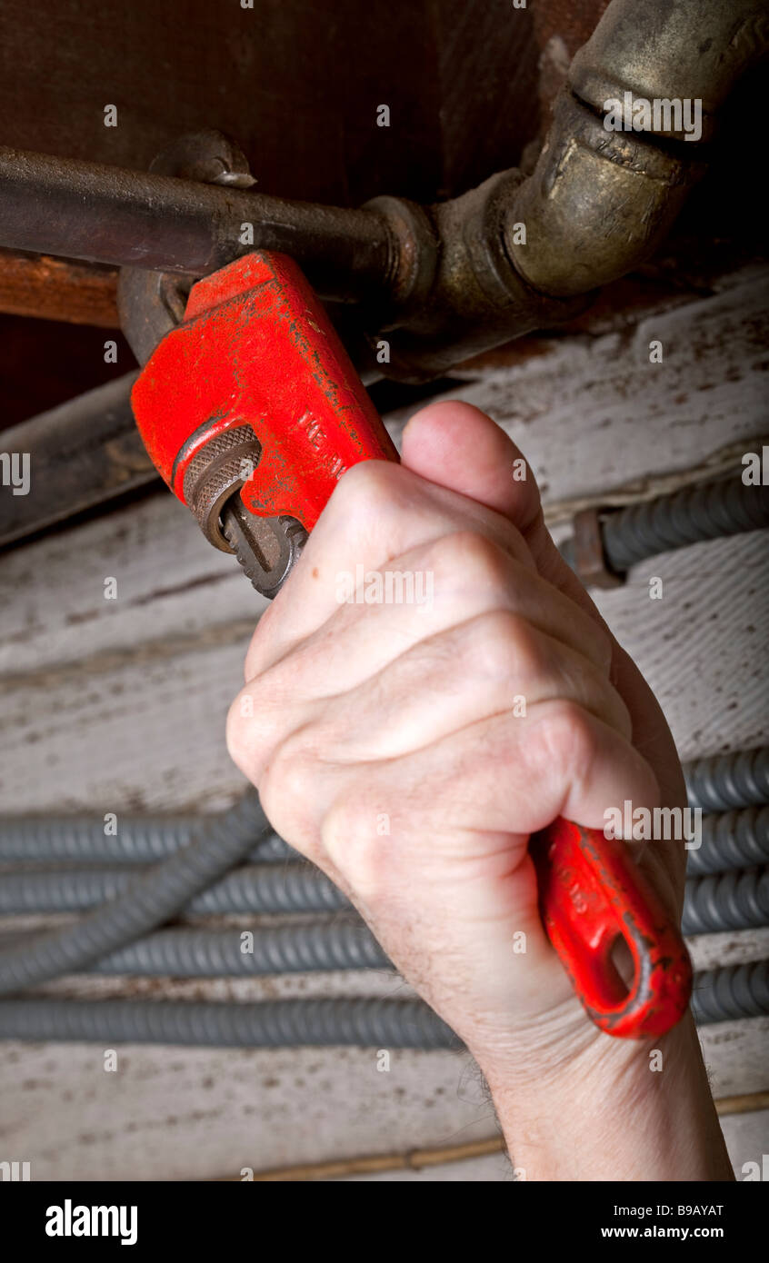 Una mano su di una chiave a tubo o una chiave Stillson il serraggio di tubi in casa idraulici. Foto Stock