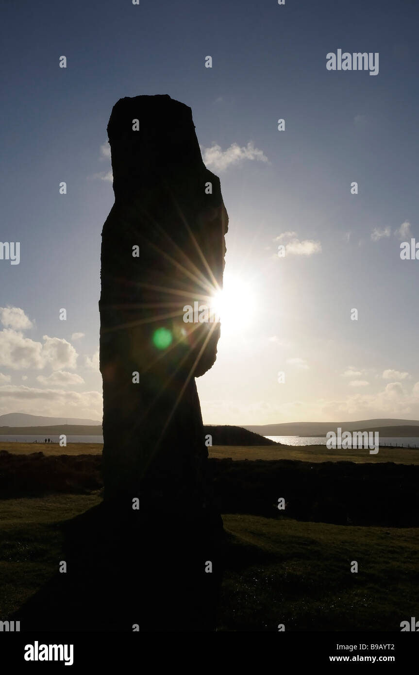 Pietra permanente, retroilluminato contro il sole di setting, al Neolitico antico henge dell'anello O'Bordgar, isole Orcadi, Scozia. Foto Stock