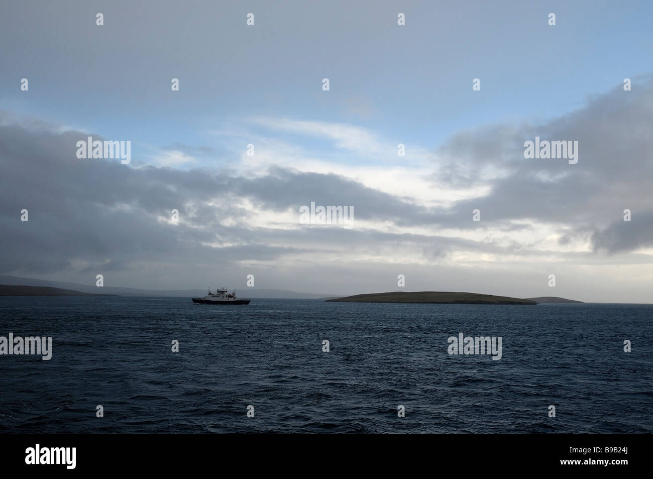 Vista del traghetto passeggeri di inversione tra Shetland continentale e l'isola di urlare contro un cielo modificabile. Foto Stock