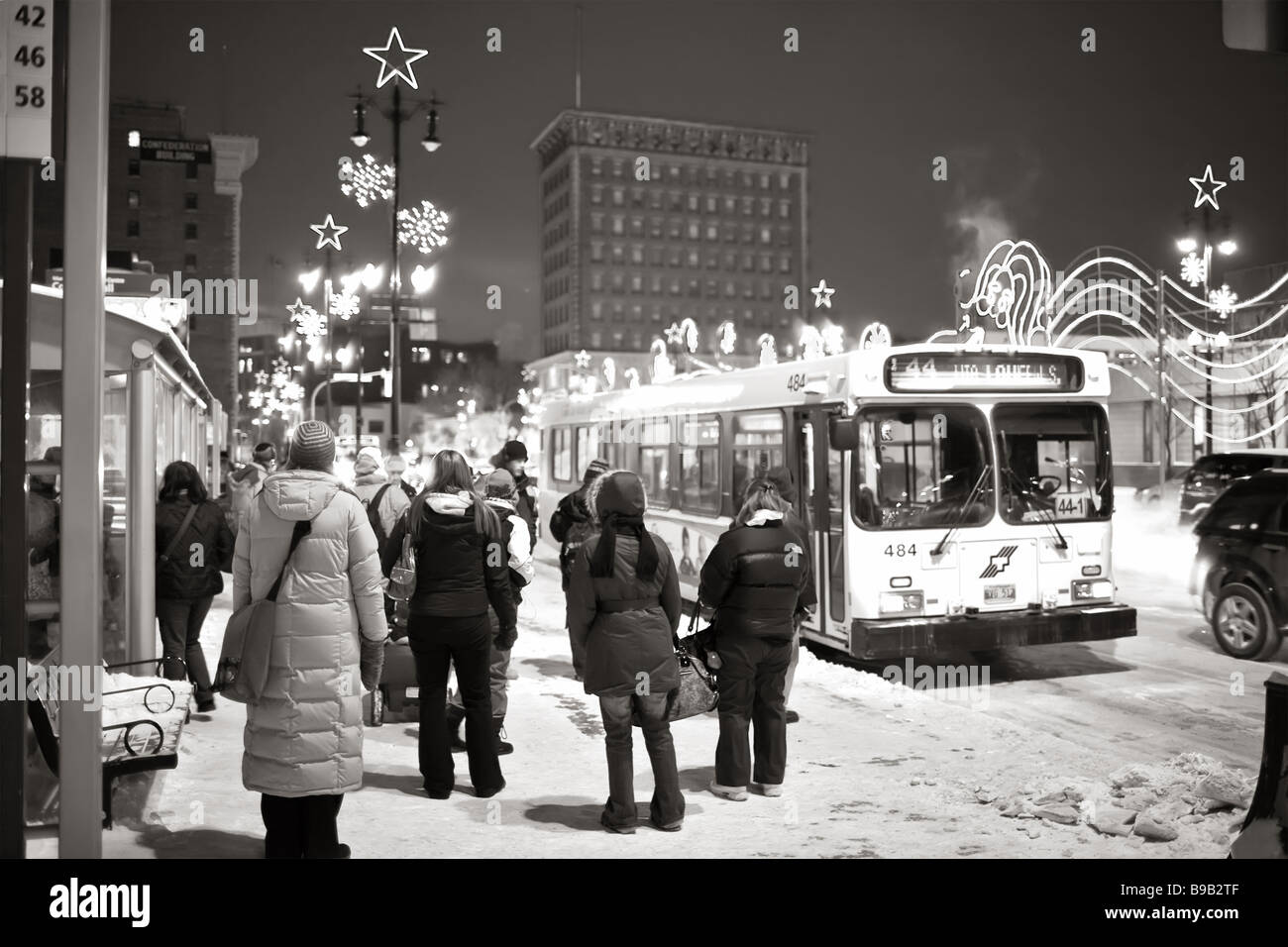 Pendolari in attesa di una fermata dell'autobus in una fredda giornata invernale, nel centro di Winnipeg, Manitoba, Canada. Foto Stock
