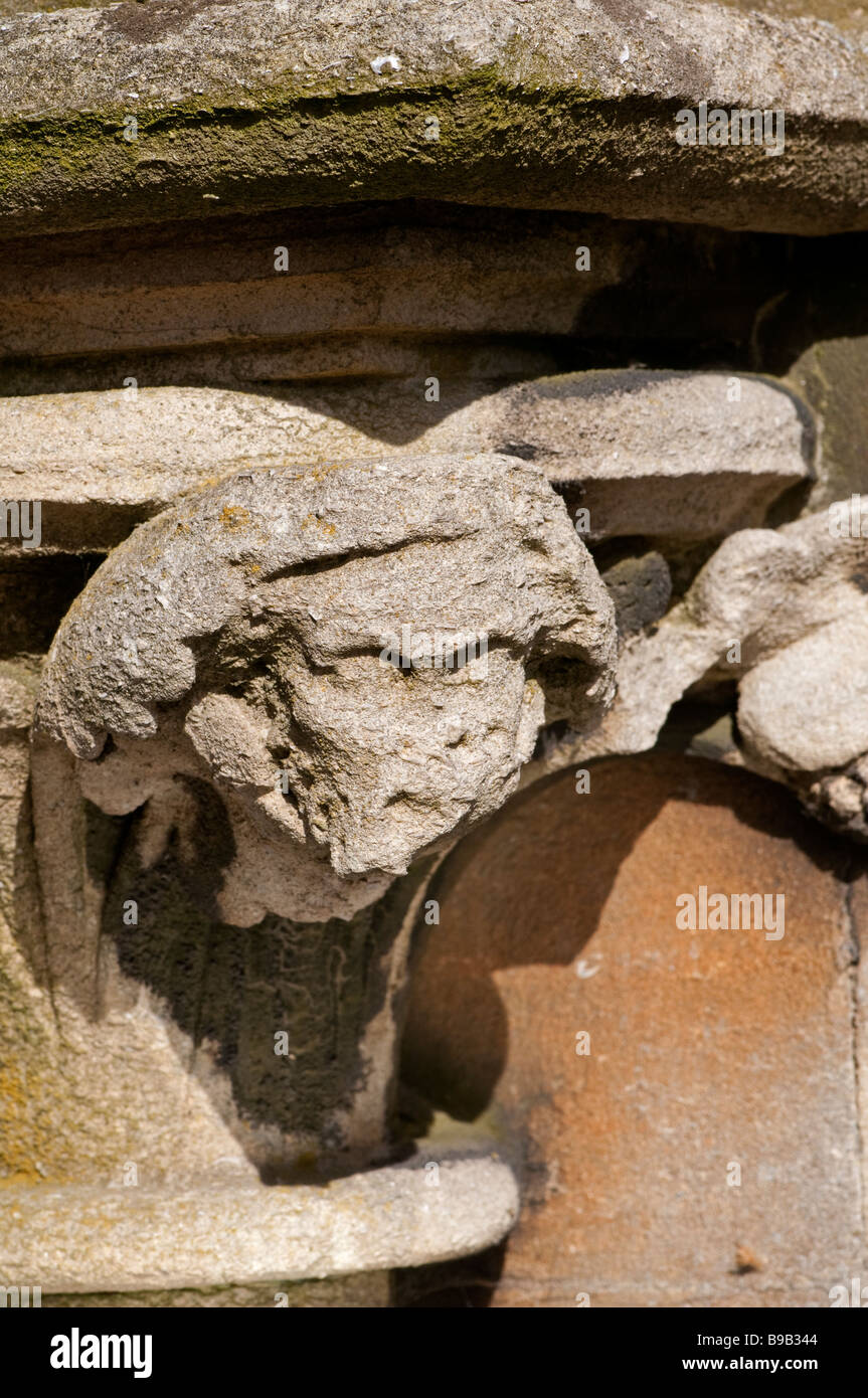 Corrosione delle murature a causa di inquinamento atmosferico. La figura di pietra sulla parete della chiesa del villaggio Foto Stock