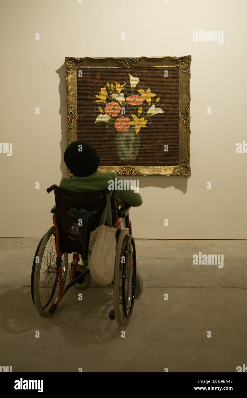 Una persona con disabilità in sedia a rotelle vede una mostra d'arte a Tel Aviv Israele Foto Stock