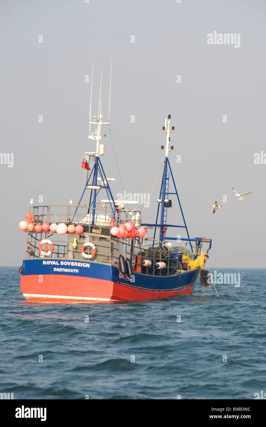 Peschereccio Royal Sovereign sollevamento di lobster pot in mare nel canale in inglese Foto Stock