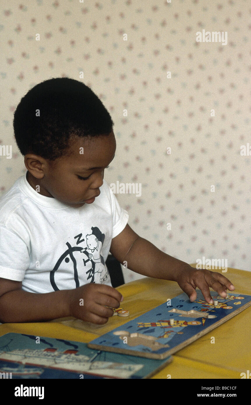 La scuola materna di ragazzo giocando con puzzle Foto Stock