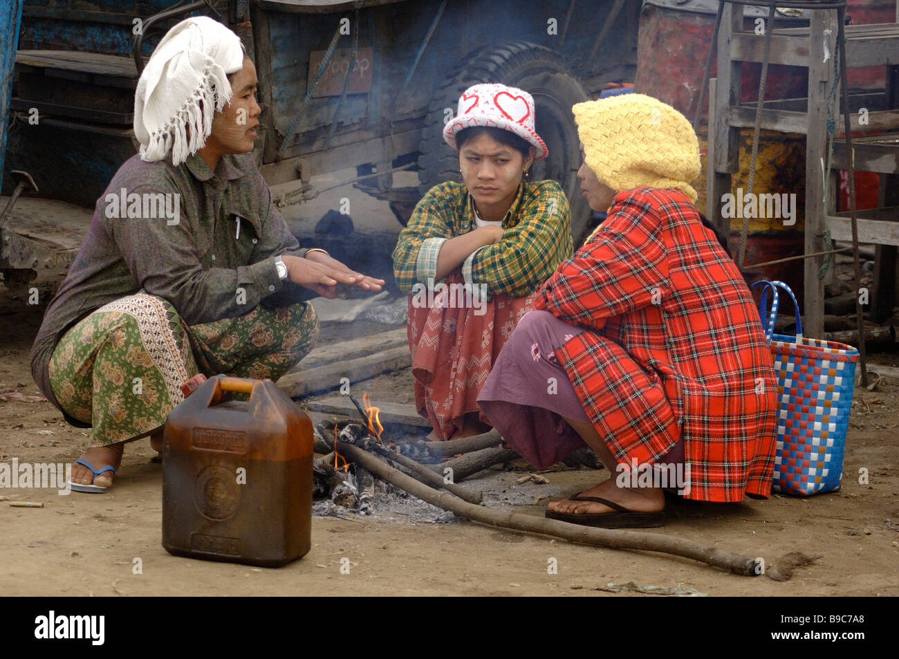 Giorno birmano operaio seduto sul Piccolo incendio presso la stazione del traghetto di Mandalay Myanmar Foto Stock