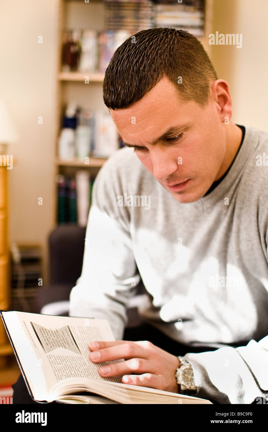 Un giovane europeo orientale uomo legge un libro Foto Stock