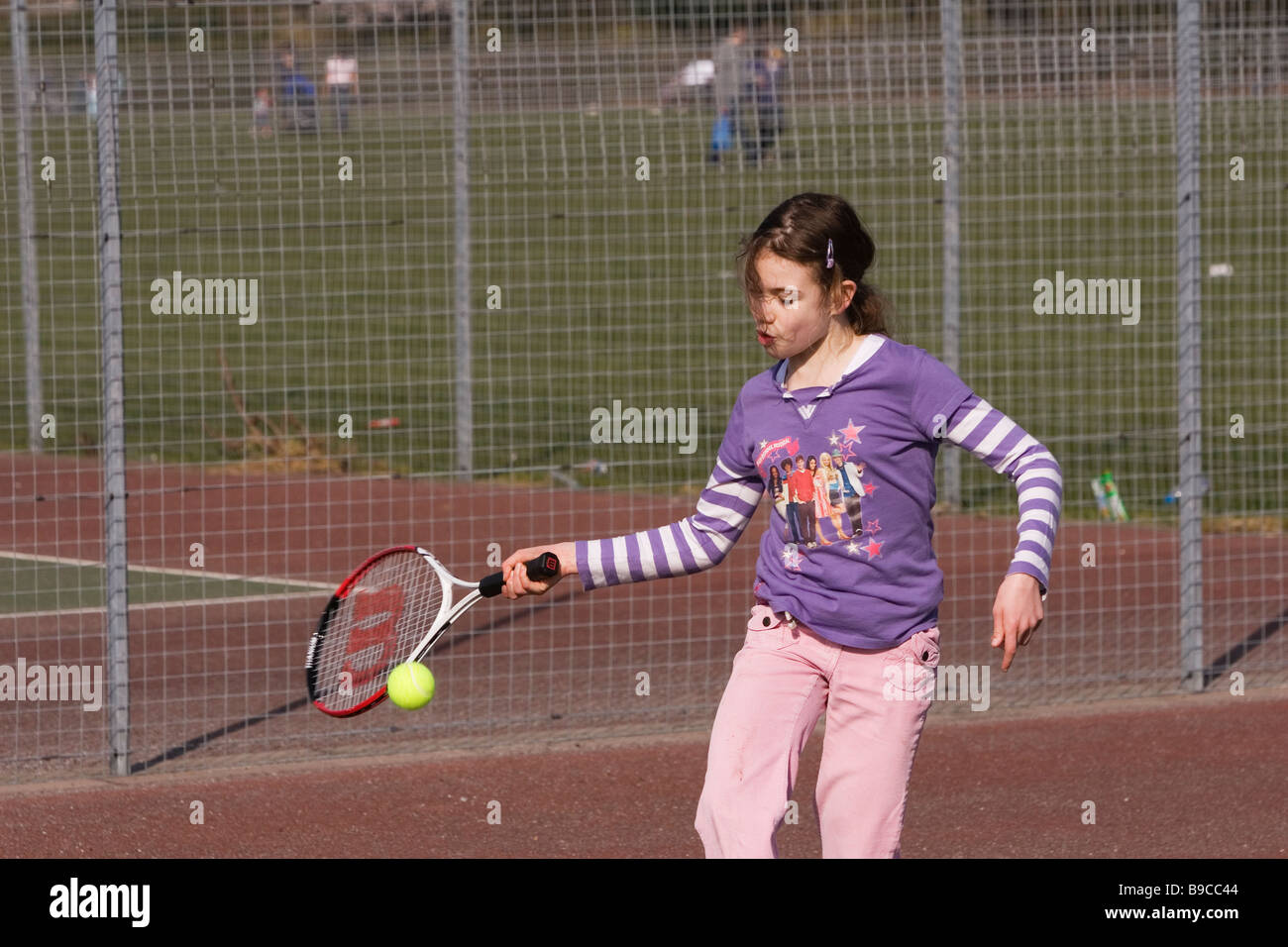 Bambino gioca a tennis in posizione di parcheggio Foto Stock