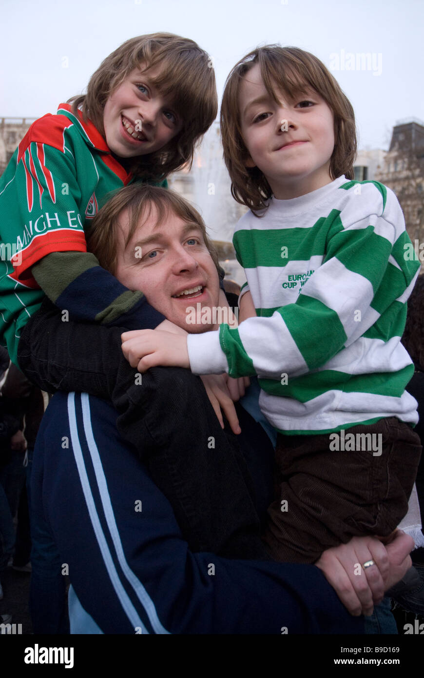 Padre con i suoi figli per celebrare il giorno di San Patrizio a Trafalgar Square a Londra Foto Stock