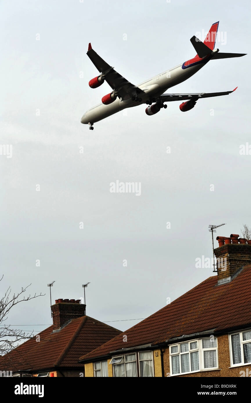 Aeromobile sul finale di approccio all'aeroporto di Londra volando a bassa quota sopra i tetti delle case Foto Stock