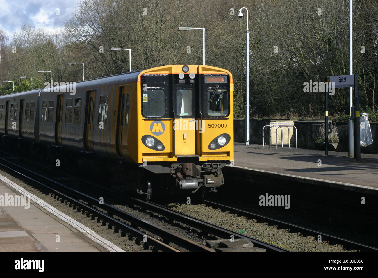 Un treno elettrico che arrivano ad una stazione rurale platform Foto Stock