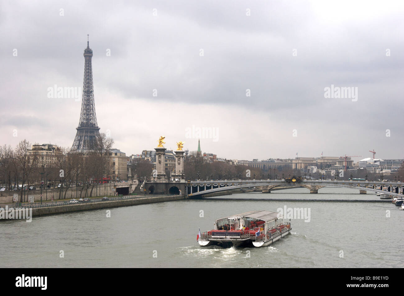 Una vista del Fiume Senna Parigi Francia mostrante una imbarcazione turistica la Torre Eiffel e il ponte Alexandre III Foto Stock