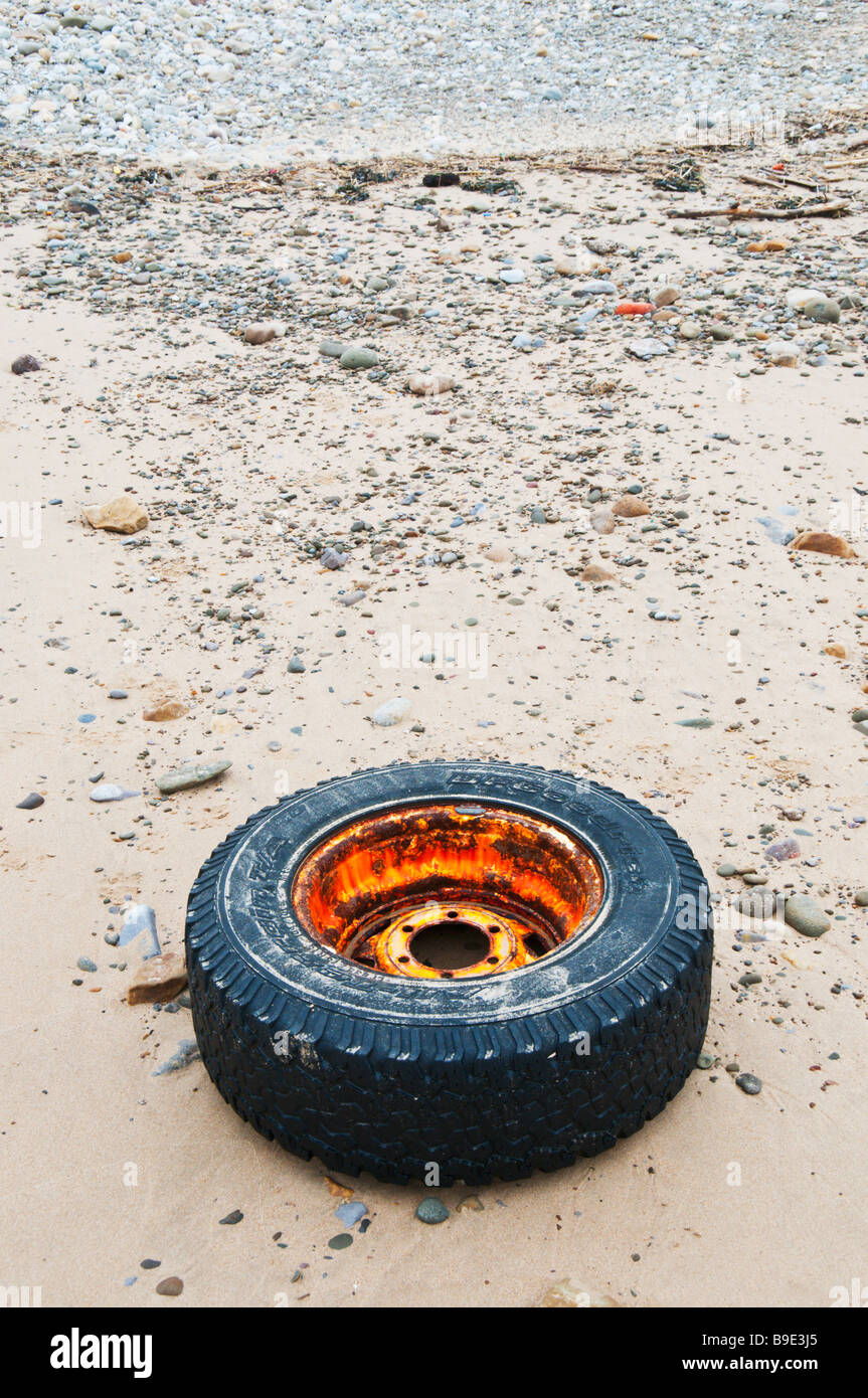 Un vecchio carrello ruota e pneumatico lavato fino a una spiaggia del Regno Unito Foto Stock