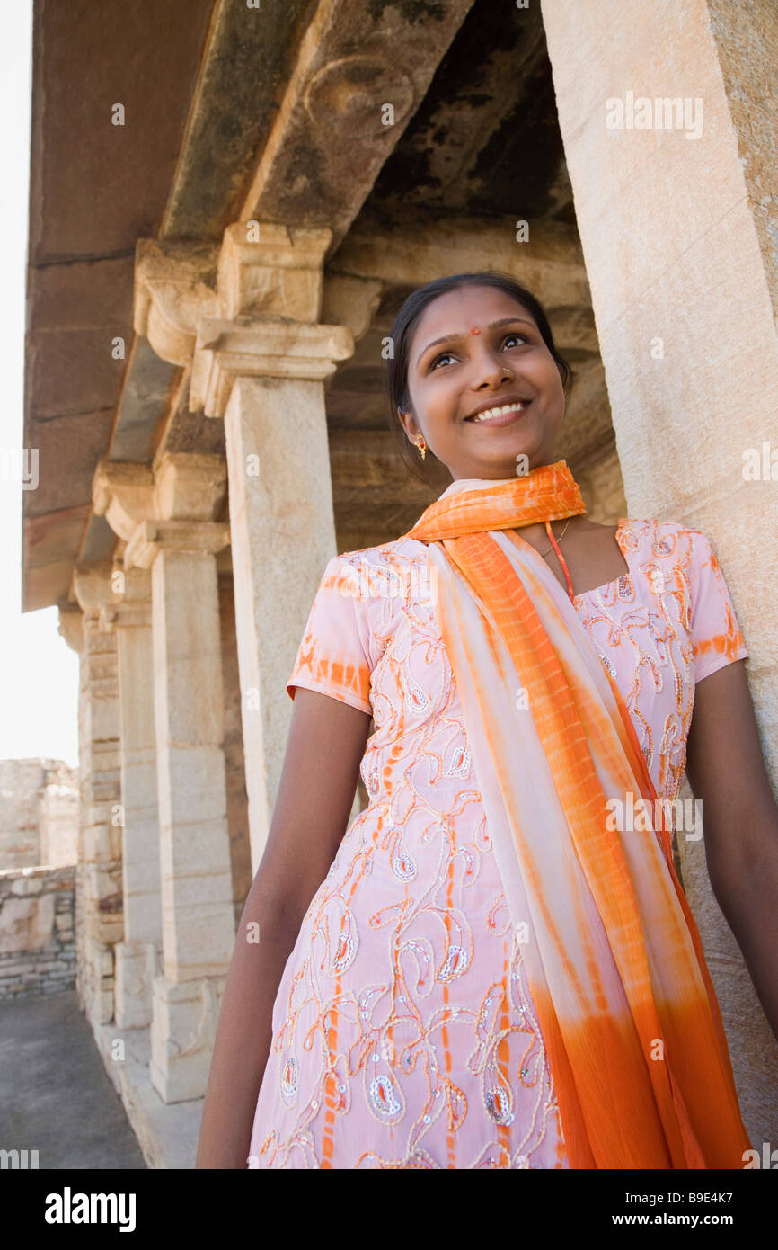Donna in piedi in un palazzo e sorridente, Chittorgarh, Rajasthan, India Foto Stock