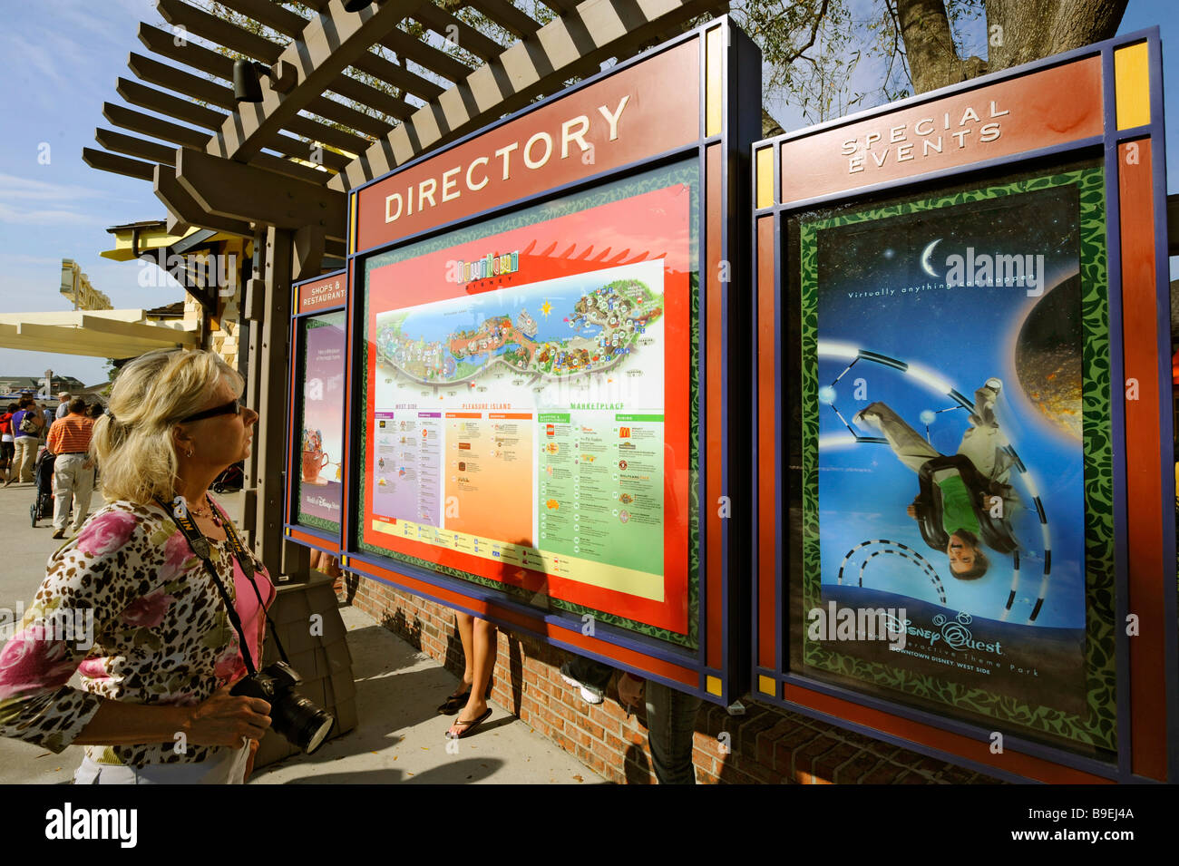 Femmina bianca visitatore di Downtown Disney studi directory mappa Foto Stock