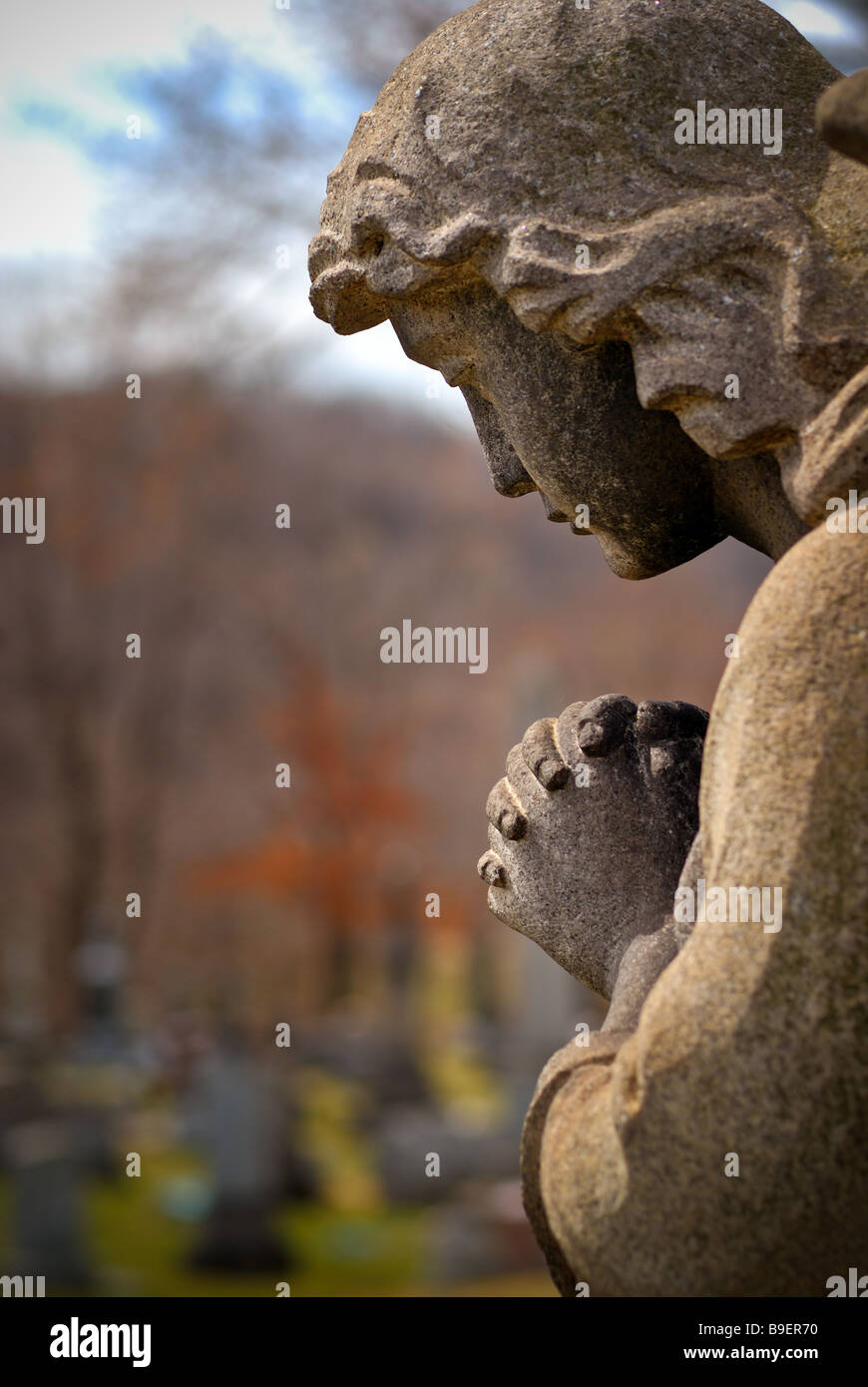 Una statua di un angelo che prega si affaccia tombe in Cristo nostro Redentore cimitero di Pittsburgh, in Pennsylvania. Foto Stock
