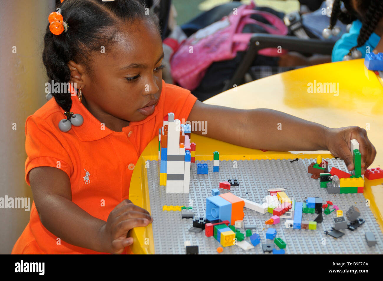 African American Girl gioca con Legos a Downtown Disney di Orlando in Florida Foto Stock