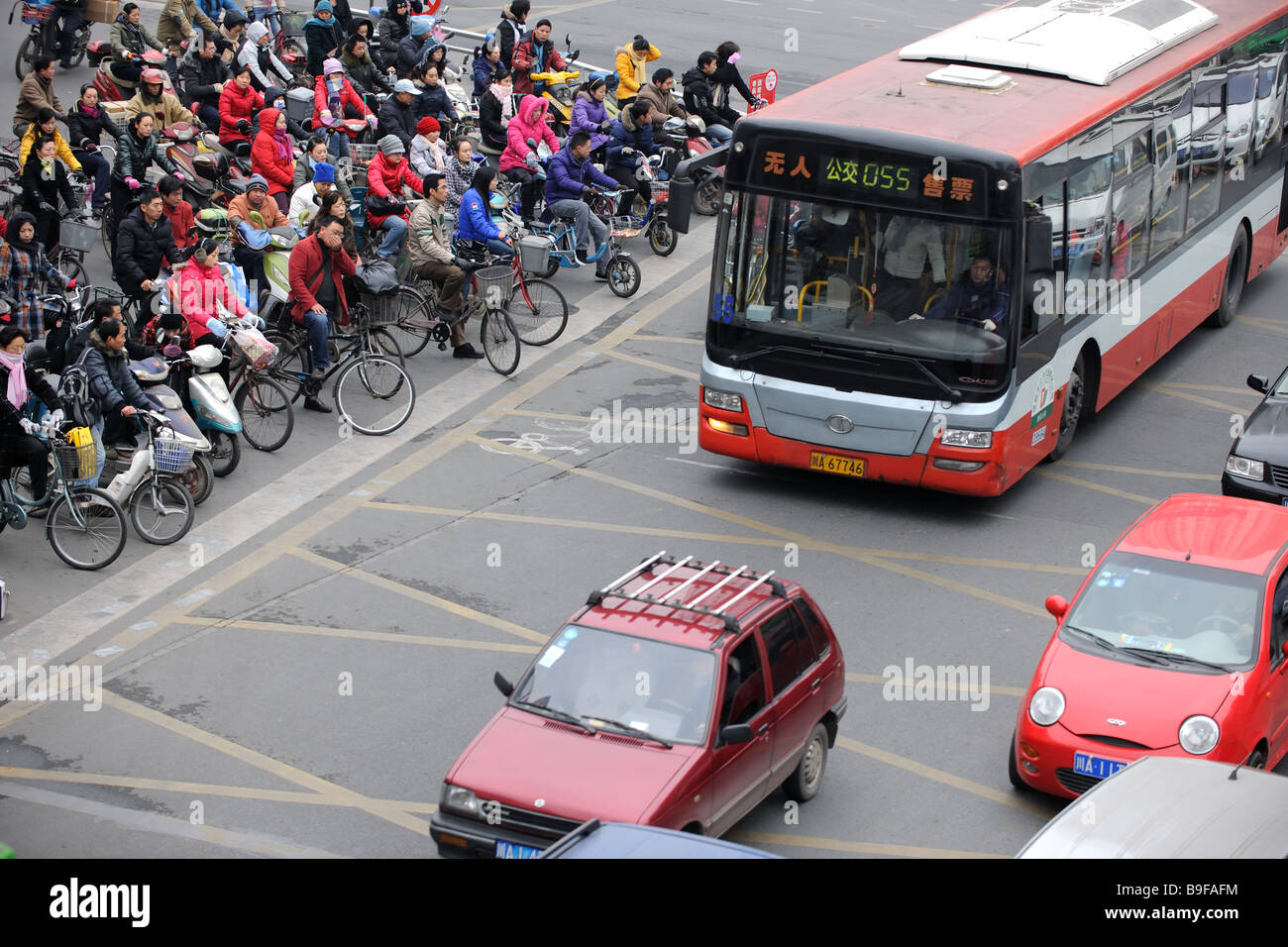 Folla su biciclette e motociclette attraversando in Shanghai Foto Stock