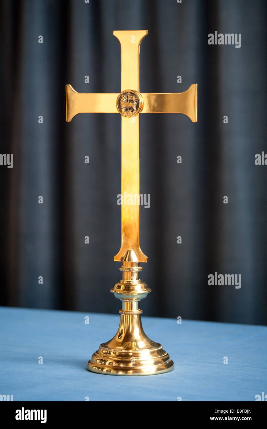Ottone croce cristiana su una chiesa blu altare panno con un blu scuro dello sfondo a tendina Foto Stock