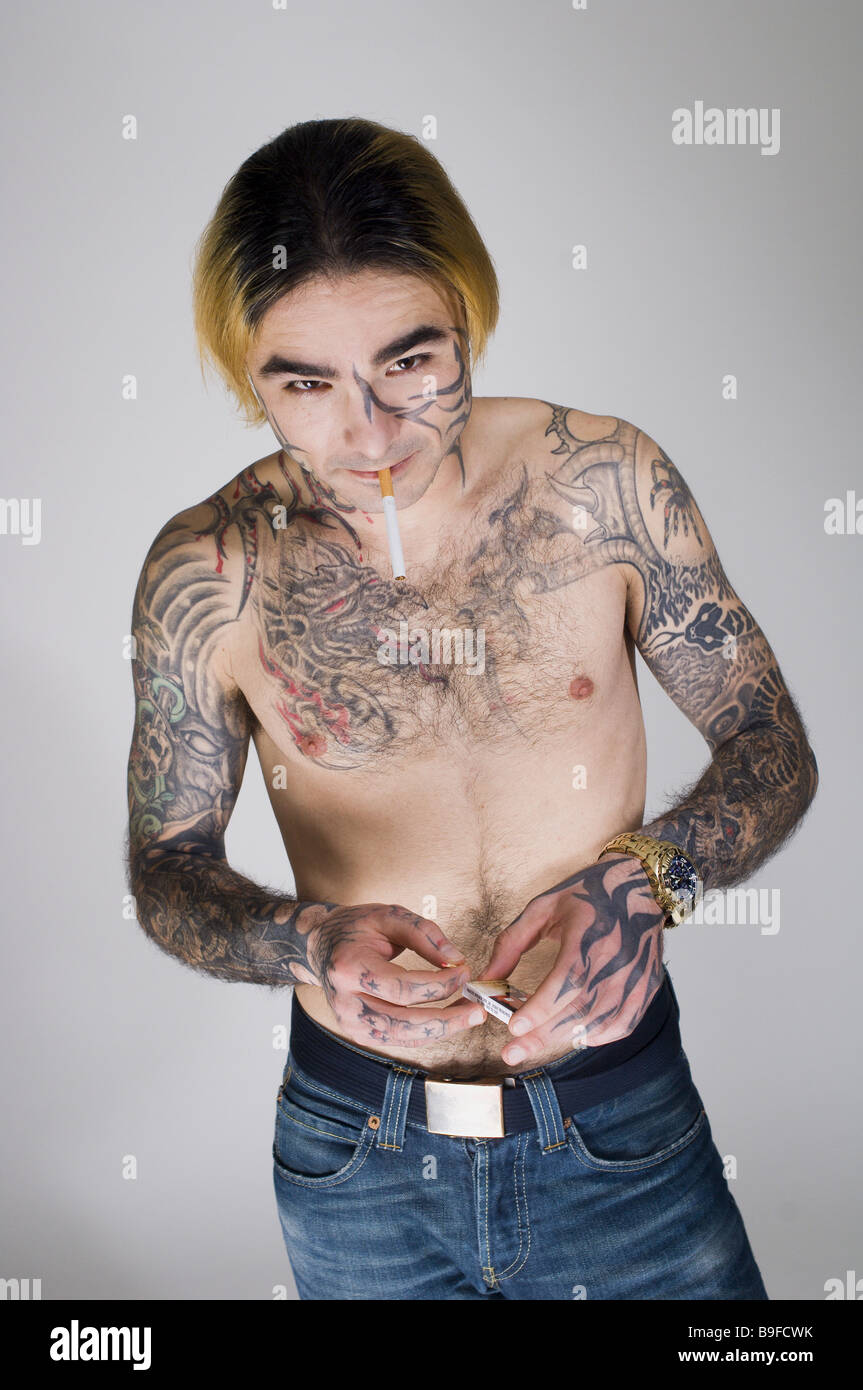 Uomo sorridente giovane corpo superiore liberamente tatuaggi sigaretta abbina le persone faccia-tattoo tatuaggi tatuaggi estensivamente vistosamente Foto Stock