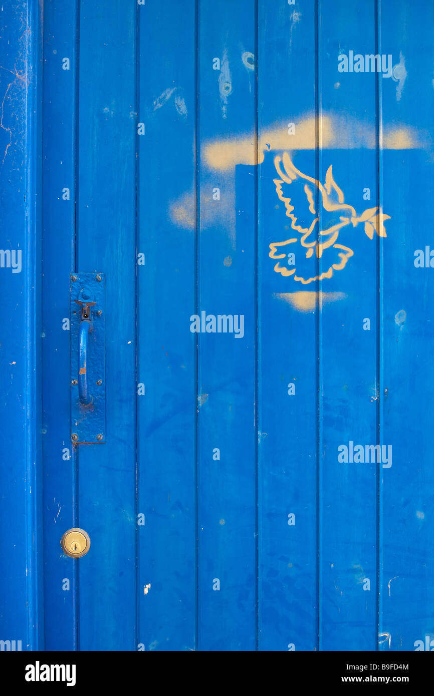 Blu porta in legno con maniglia e serratura in ottone e impresse "colomba della pace" in oro dipingere Foto Stock