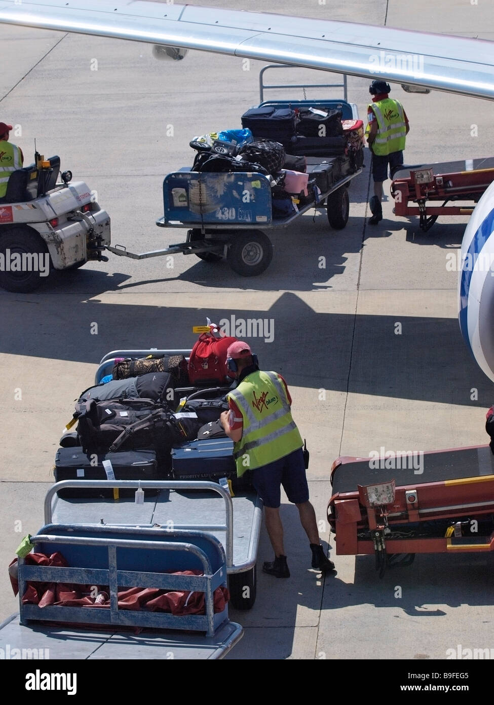 Gestore di bagaglio scarica dal piano a Melbourne Tullamarine INTERNATIONAL AIRPORT VICTORIA AUSTRALIA Foto Stock