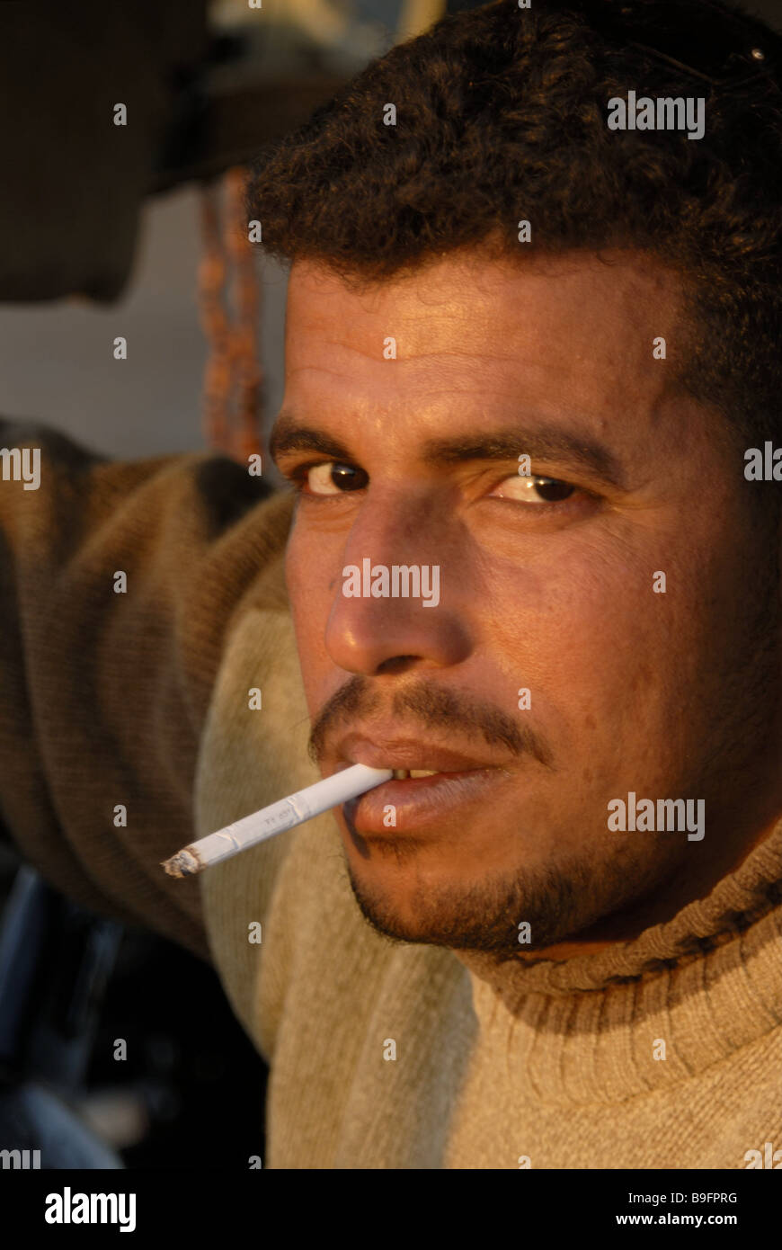 Egitto uomo Fumi sigarette ritratto brocciata Africa persone native egiziani fumatori seriamente la fiducia in sé stessi la sera-sun Foto Stock