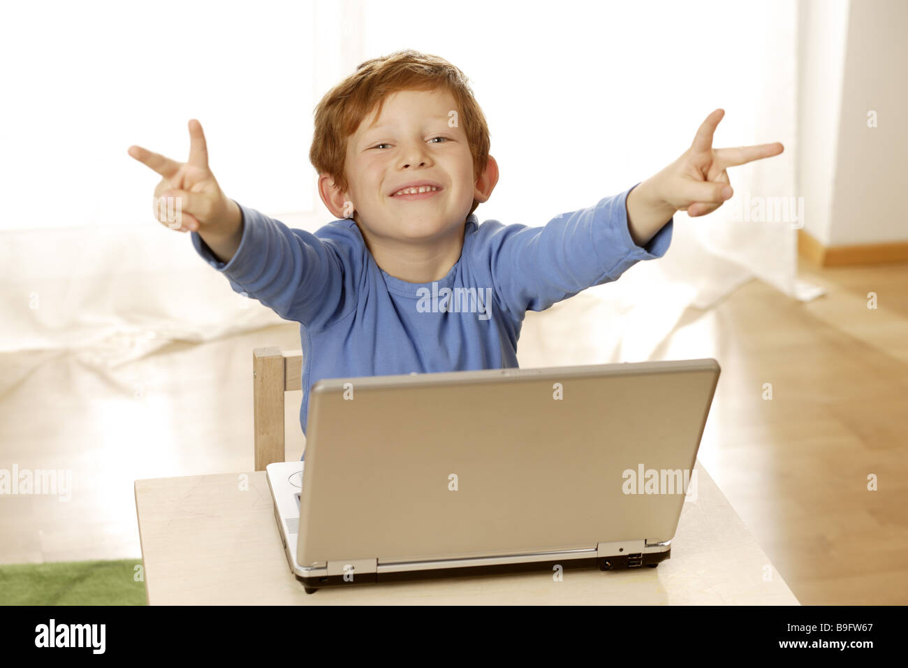 Ragazzo Notebook gesto sorridente V-Zeichen dettaglio persone serie bambino dai capelli rossi allegramente gioia contentezza computer wireless Foto Stock