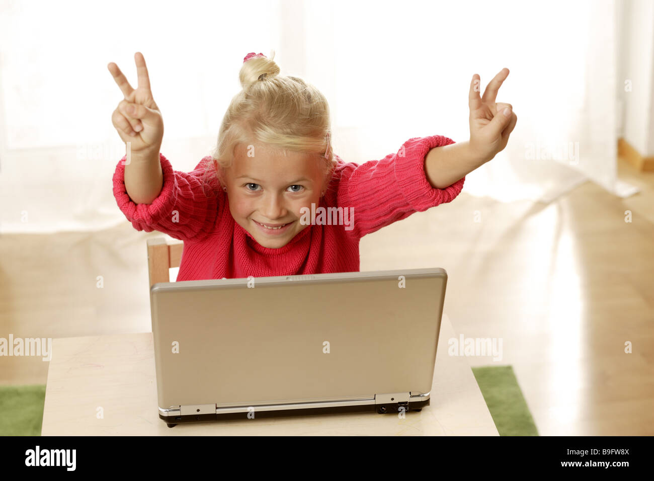 Ragazza gesto Notebook ridere V-Zeichen dettaglio persone serie bambino biondo malioni con collo alto allegramente orgoglio di gioia i computer wireless Foto Stock