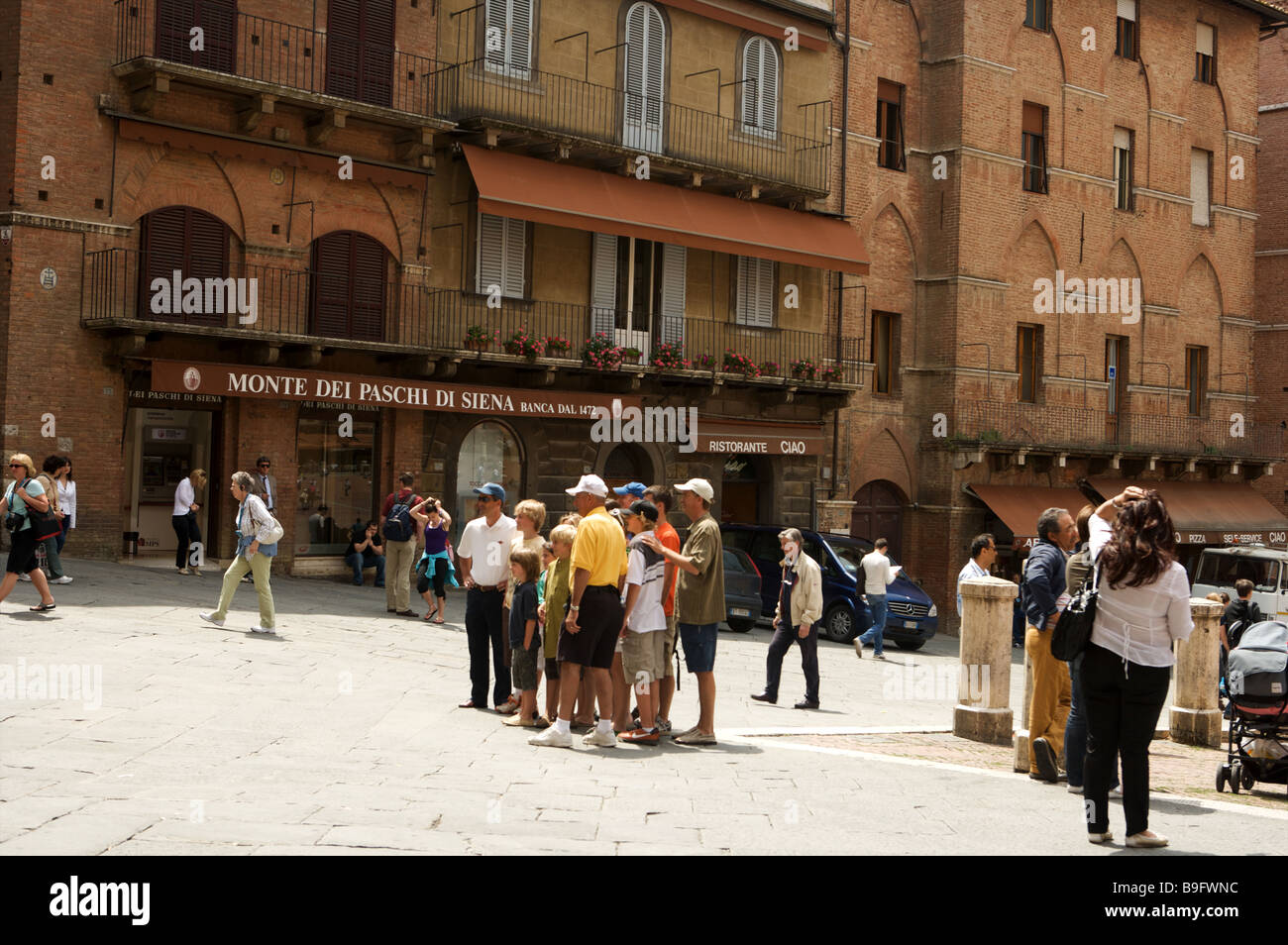 I turisti scattano fotografie in piazza de Campo a Siena Italia Foto Stock