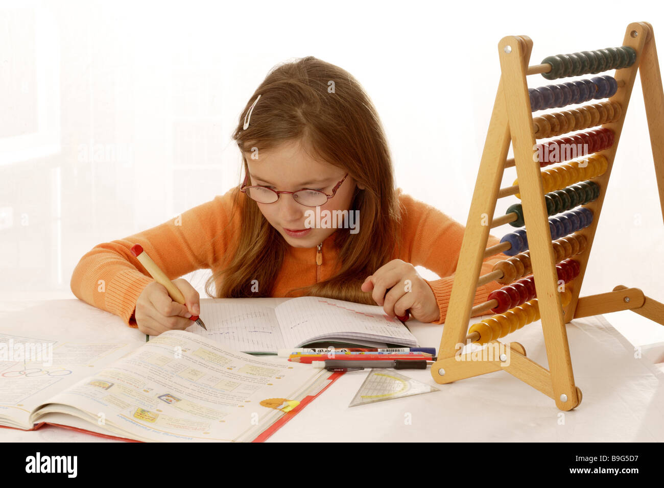 8-10 anni abacuses vetri Vetri-portatore brunette semi-portrait compiti interna del notebook bambino ritratto di concentrazione Foto Stock