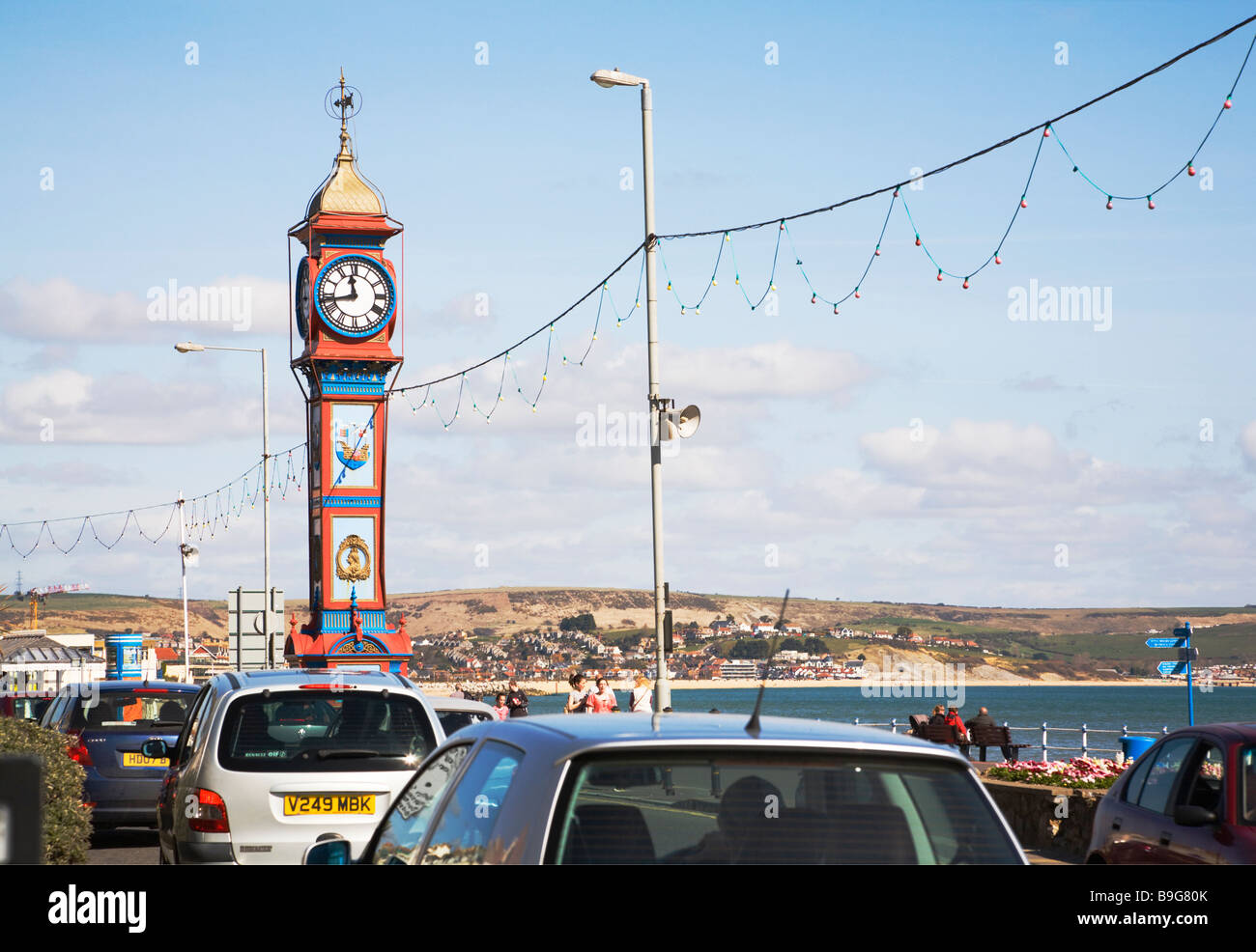 Orologio del Giubileo e il traffico lungo la trafficata strada lungomare. Città balneare di Weymouth, Dorset. Regno Unito. Foto Stock