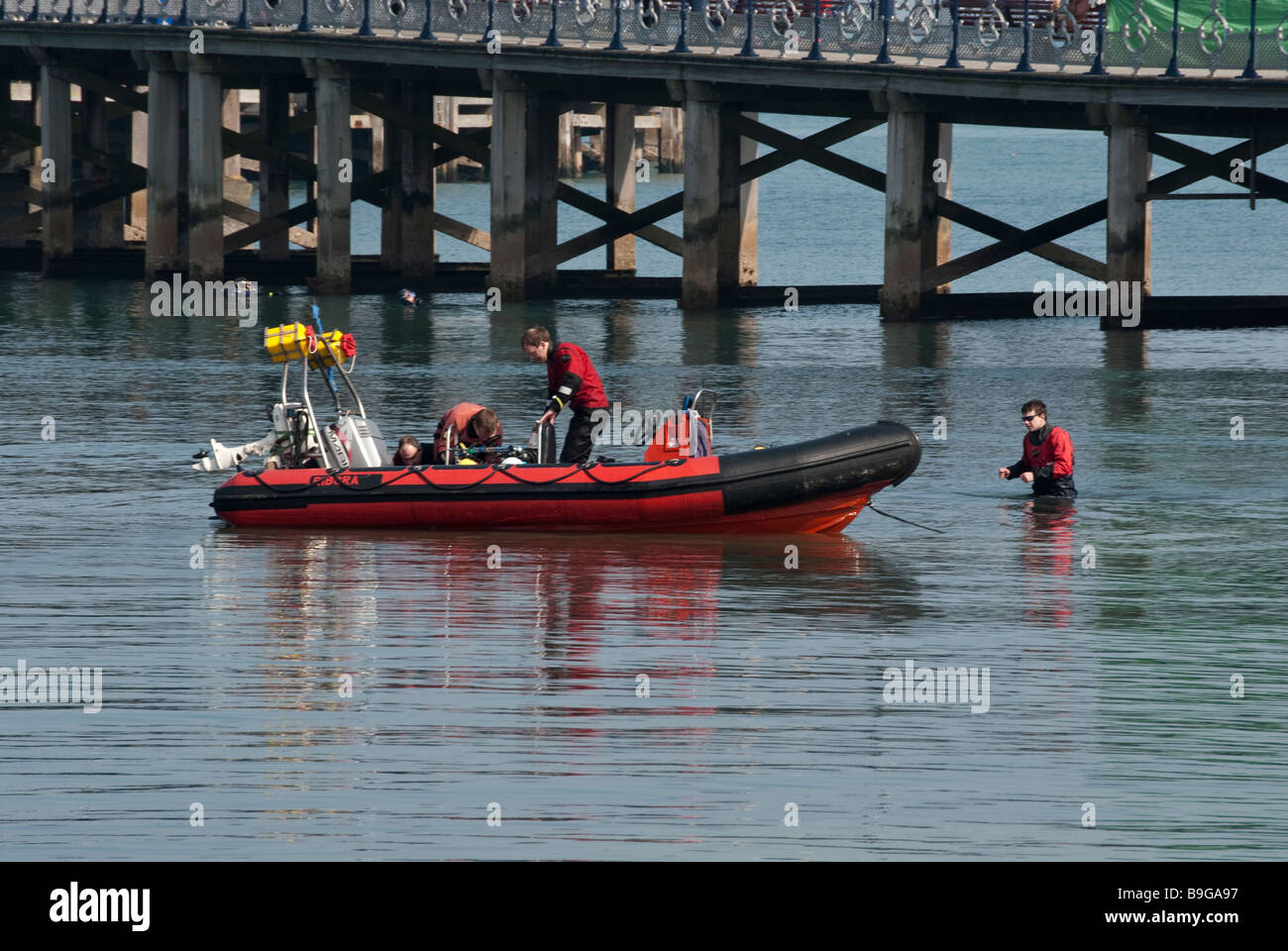 I subacquei preparazione barca gonfiabile da Pier a Swanage Foto Stock