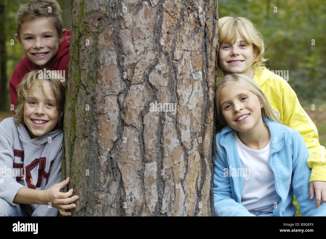 Bambini Ragazzi ragazza allegramente cavalletti log ride guardando la telecamera amici 8-12 anni quattro gruppo amicizia divertente gioco insieme la gioia Foto Stock