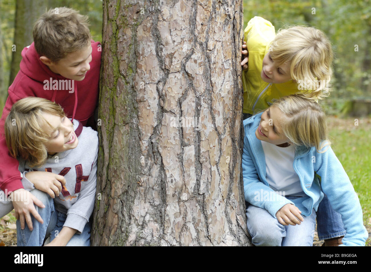 Bambini Ragazzi ragazza allegramente cavalletti log ride il contatto visivo amici 8-12 anni quattro gruppo amicizia divertente gioco insieme la gioia Foto Stock