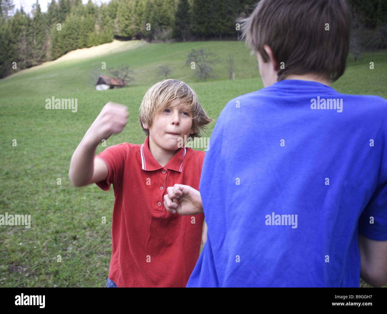 Prato ragazzi combatte lateralmente persone 11-13 anni bambini due amici di infanzia nemici controversia wrangling lotta risse rivali Foto Stock