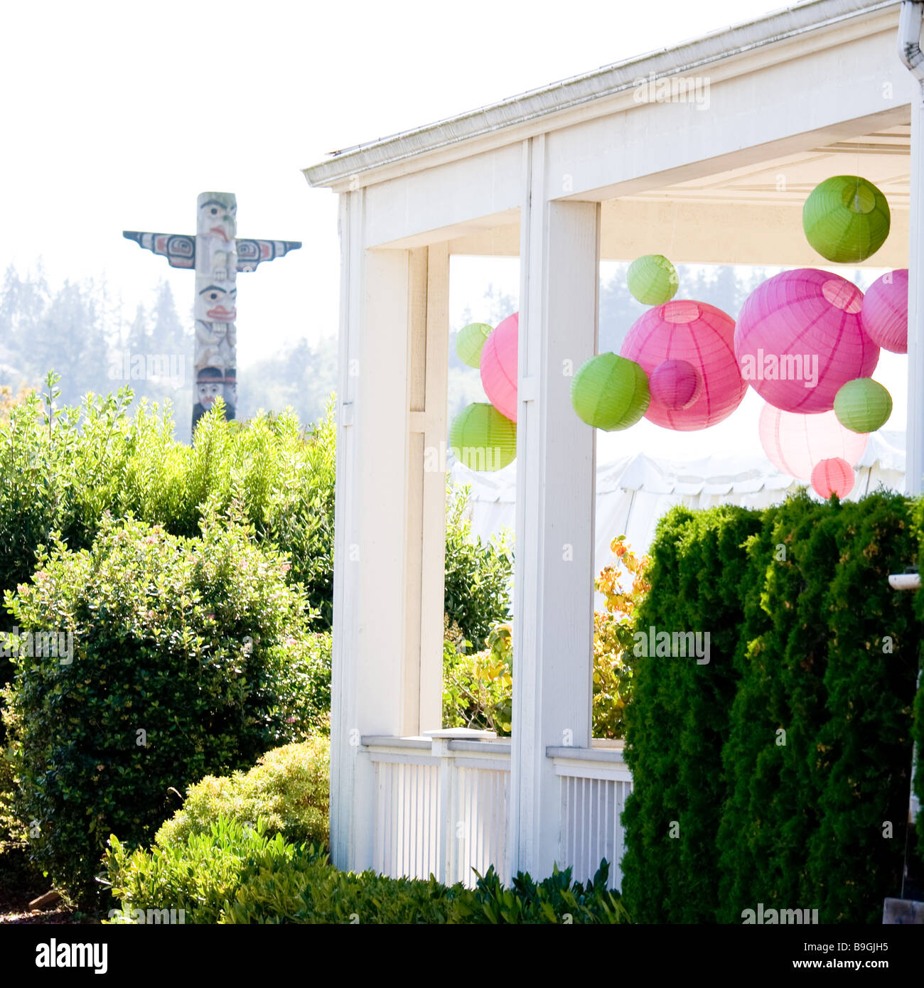 Il totem pole e veranda decorata con luminosi di colore verde e rosa lanterne giapponesi in colori di nozze Foto Stock