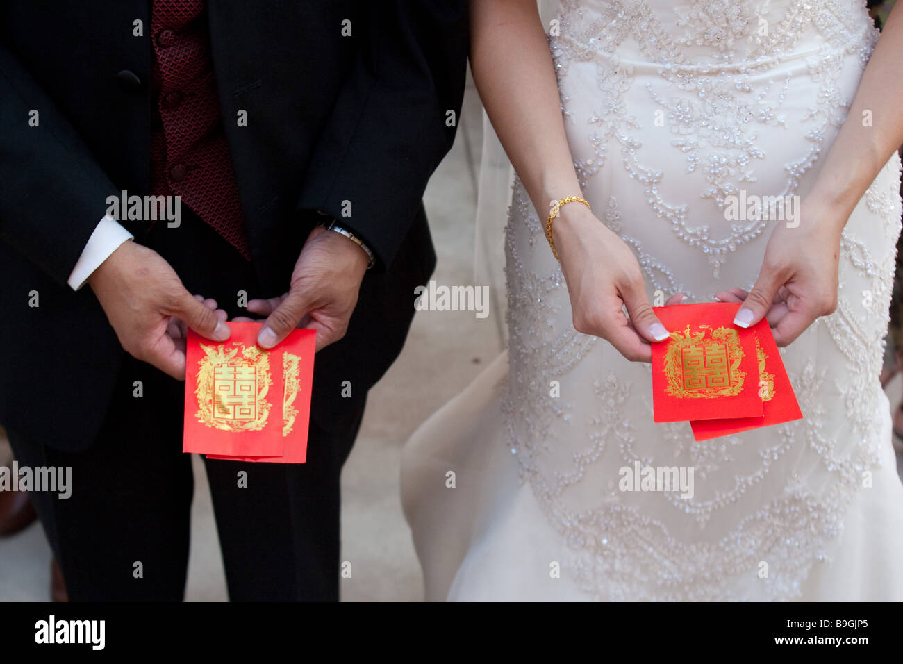 Asiatico-americano matura la ricezione di matrimonio tradizionale doni in denaro in buste rosse alla loro ricezione Foto Stock
