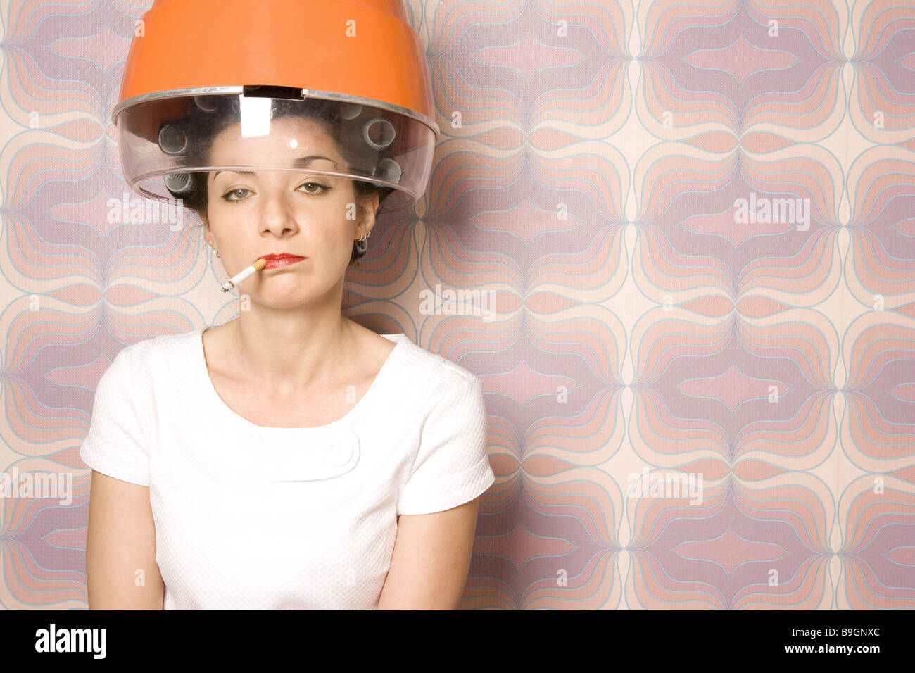 Salone di coiffeur donna bigodini essiccatore Fumi sigarette semi-portrait 20-30 anni 70er anni bellezza donna parrucchiere-visita Foto Stock