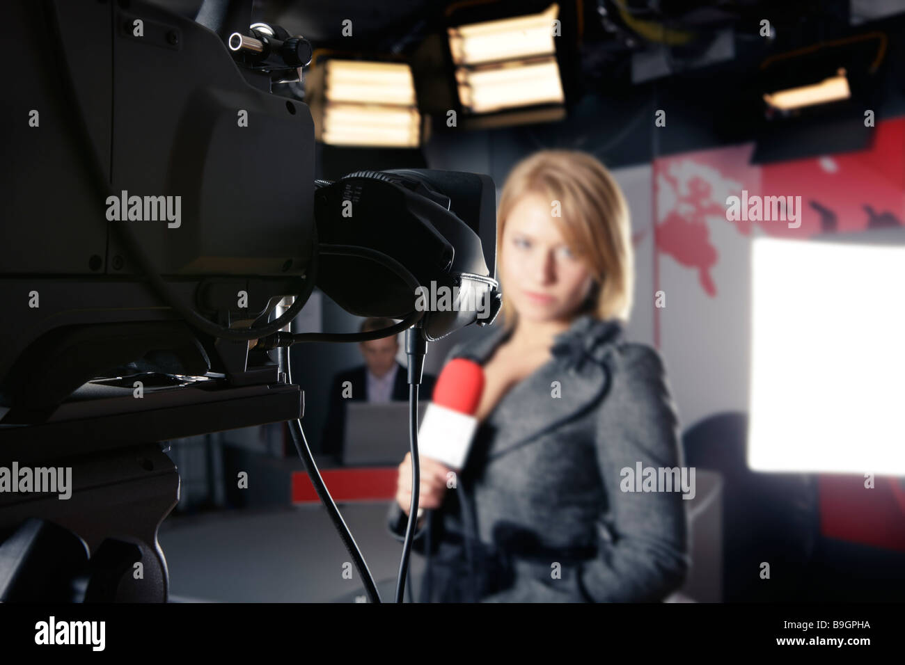 Studio TV con close up su una videocamera e un irriconoscibile donna presenter in background Foto Stock