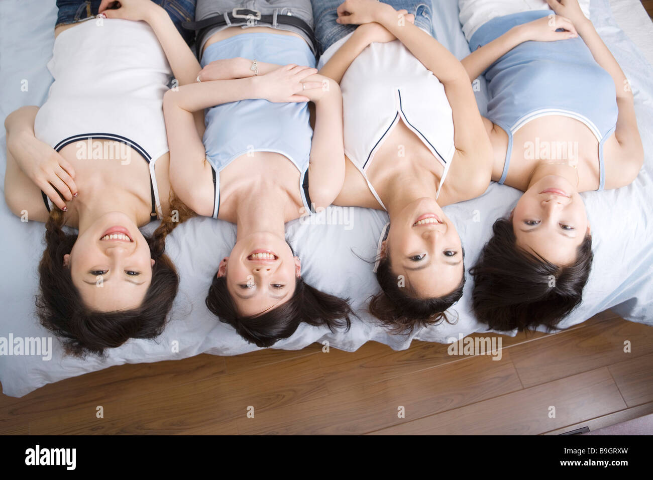 Quattro giovani donne che giace sul retro ritratto sorridente Foto Stock