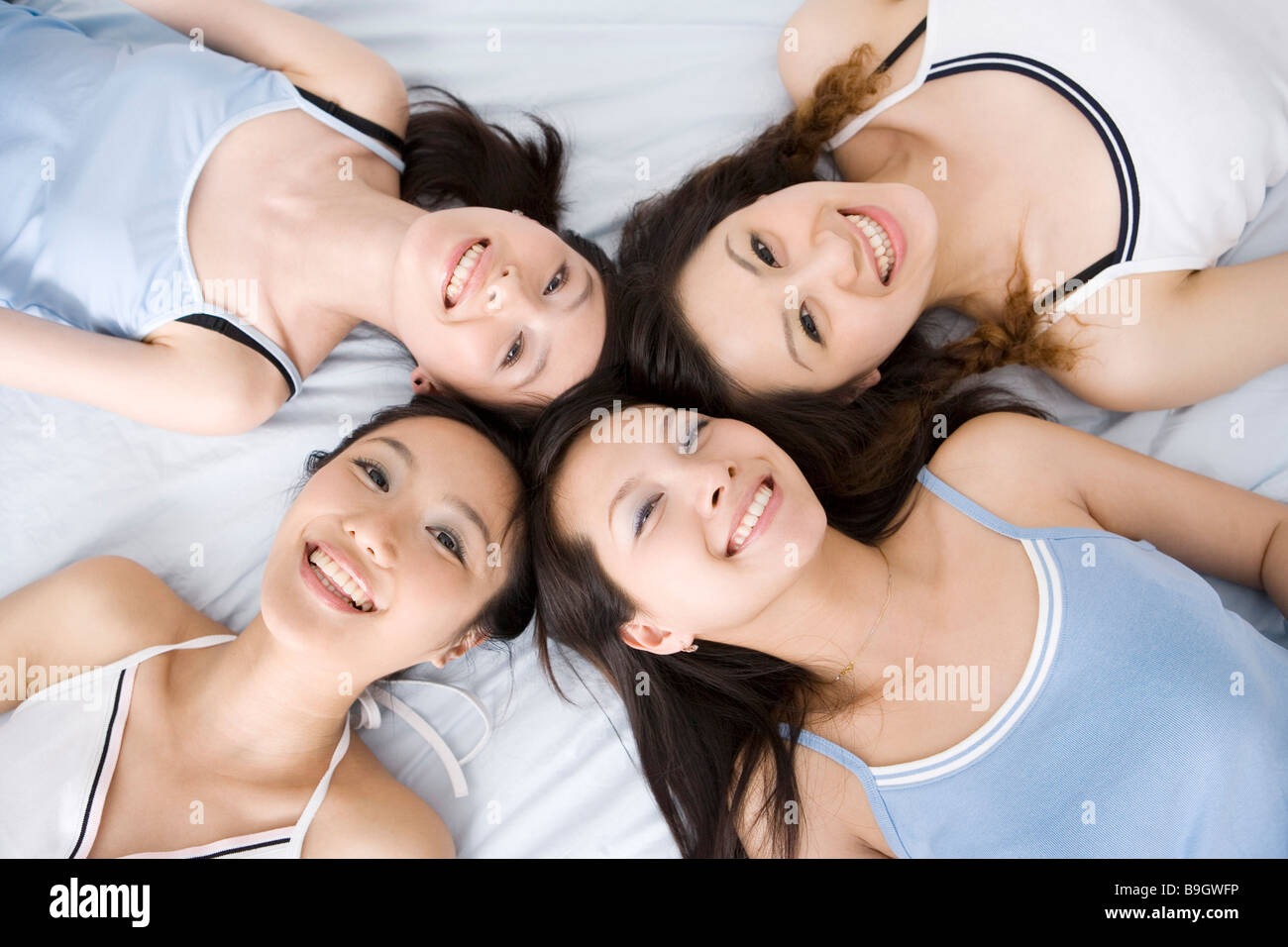 Quattro giovani donne giacente in cerchio su letto vista aerea Foto Stock
